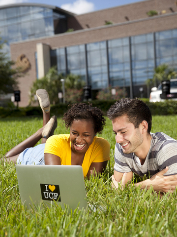 Students on a lawn with a laptop